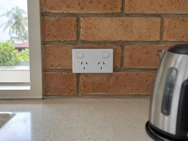 Double power point on a brick kitchen splashback above a benchtop in Burleigh Waters